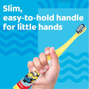 Child's hand holding a slim yellow Colgate Minions toothbrush with an easy-to-hold handle.