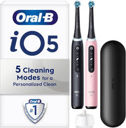 Oral-B iO5 electric toothbrush set with black and pink handles and a travel case.