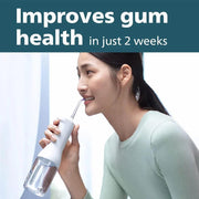 Woman using a cordless water flosser for improved gum health and oral hygiene.