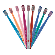 Assorted colorful Curaprox Velvet toothbrushes arranged in a fan shape on a white background.