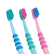 Three colorful children's toothbrushes in blue, teal, and pink with textured grips.