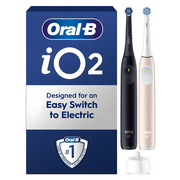 Oral-B iO2 electric toothbrush set with black and rose gold handles and charging base.