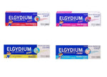 Four boxes of Elgydium kids and junior toothpaste gel in strawberry, berry, banana, and bubble gum flavors.