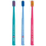 Three colorful Curaprox ultra soft toothbrushes in teal, light blue, and pink.